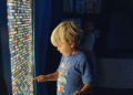A young child at MOXI plays on a screen of brightly lit squares. (Courtesy photo)